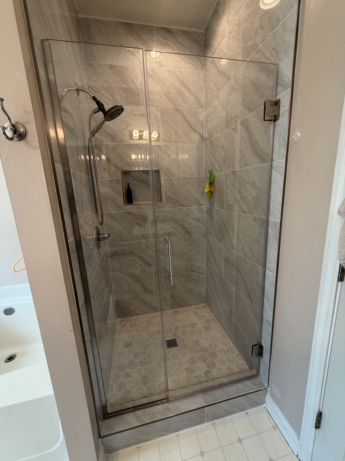 Bathroom shower with glass enclosure by Caballero C&L Remodeling