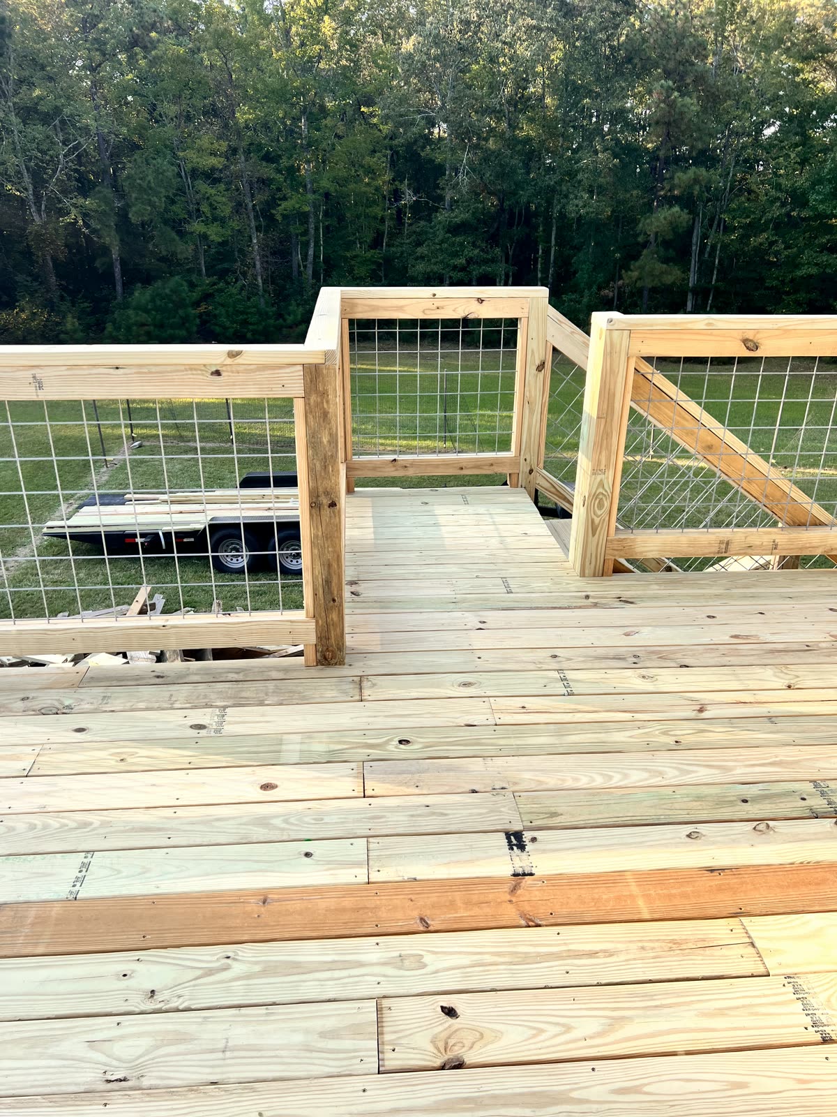 Wooden deck with wire railing by Caballero C&L Remodeling