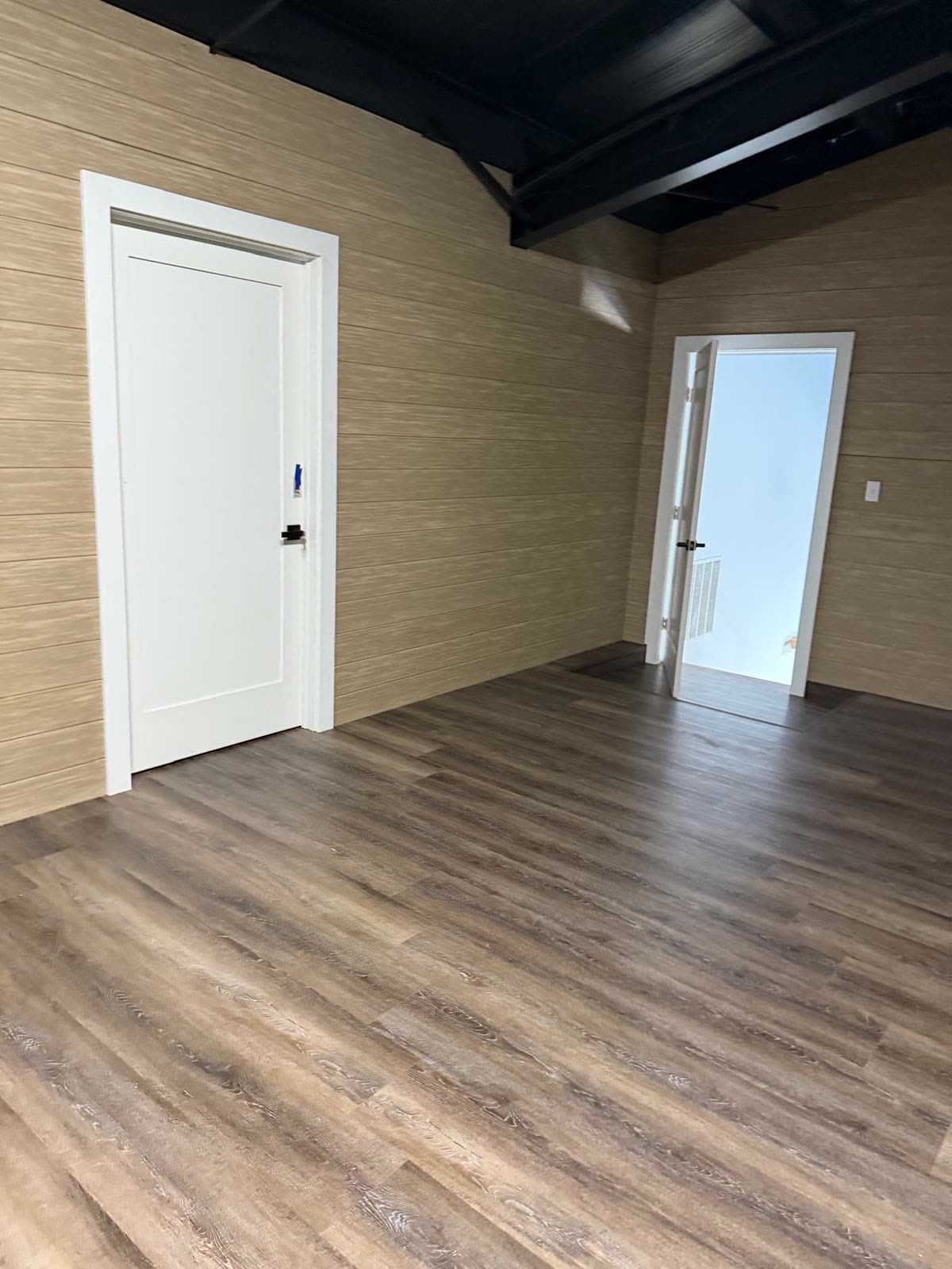 Interior with wood-look flooring and freshly painted white trim by Caballero C&L Remodeling
