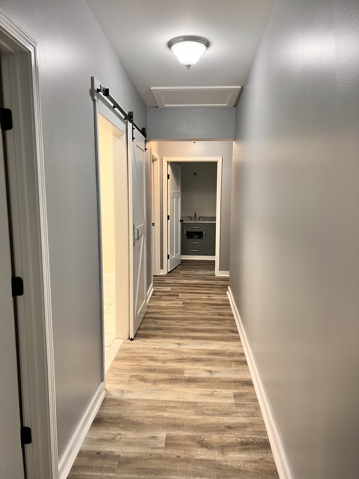 Modern hallway with barn door by Caballero C&L Remodeling