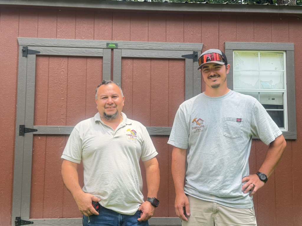 Caballero C&L Remodeling team members in front of a wooden structure