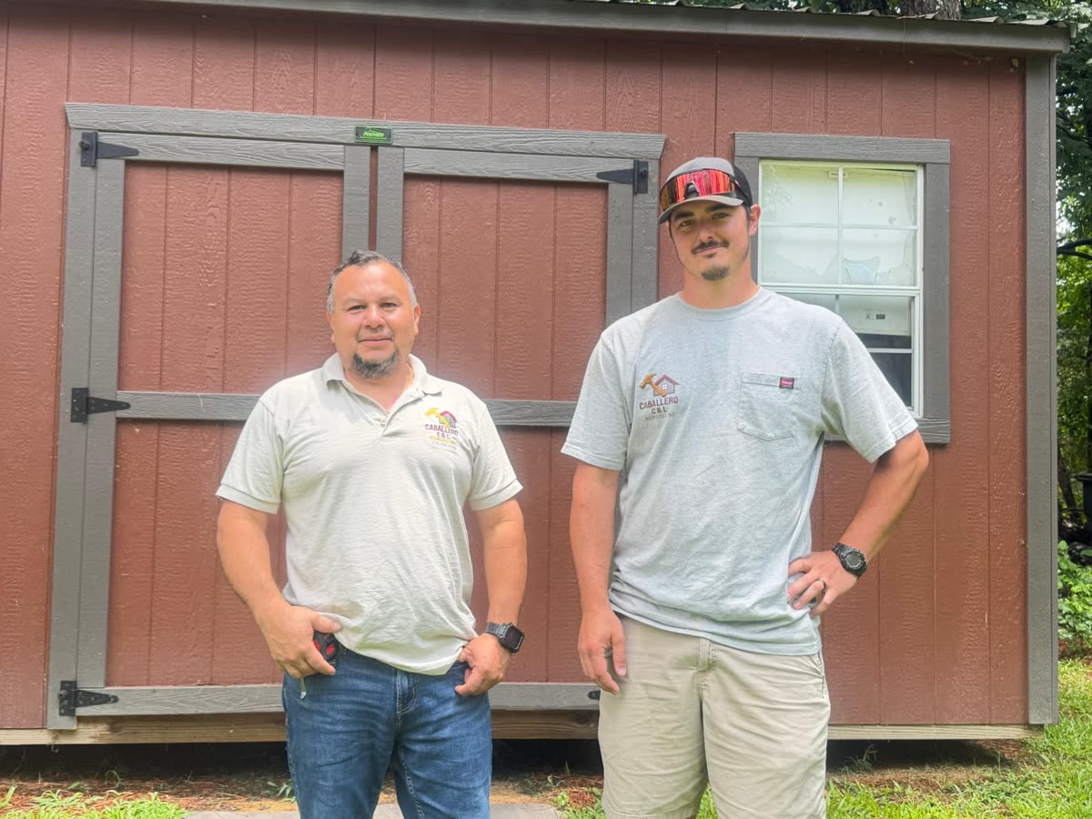 Team members in front of wooden structure